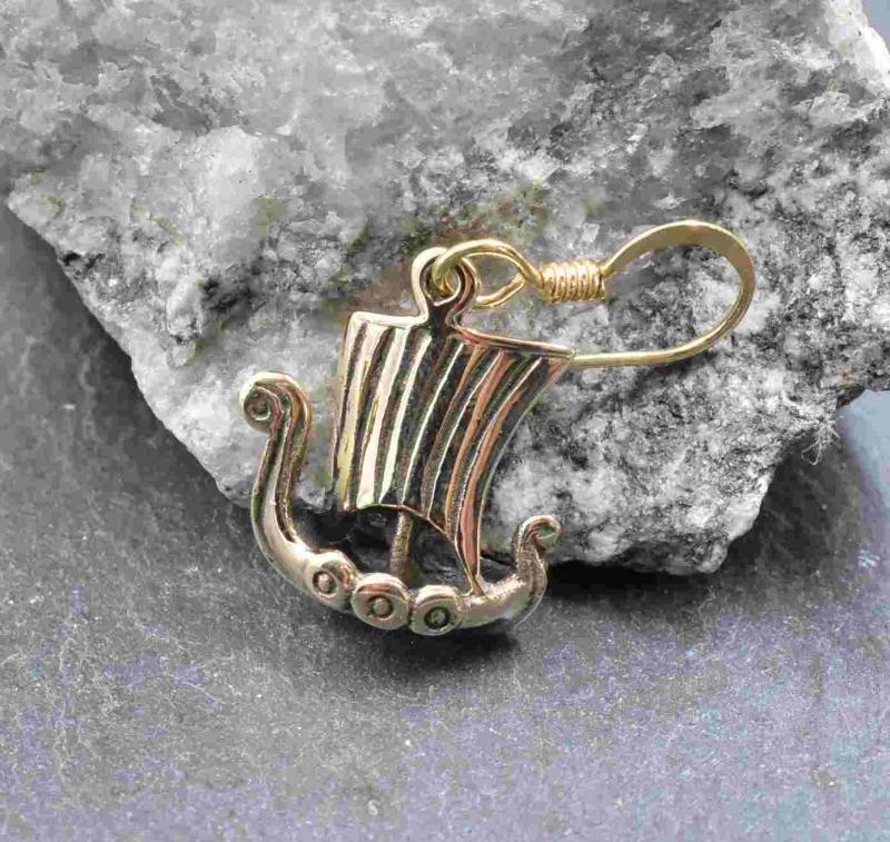 Wikinger Drachenboot Ohrhänger aus Bronze vor einem Stein